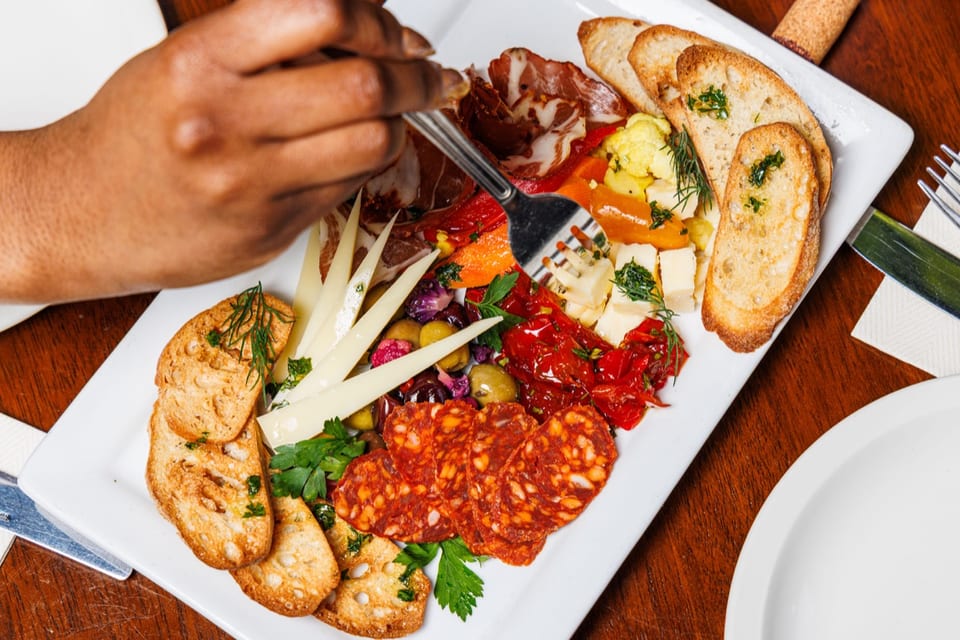 Charcuterie board with cheeses, cured meats, fruit, and crackers